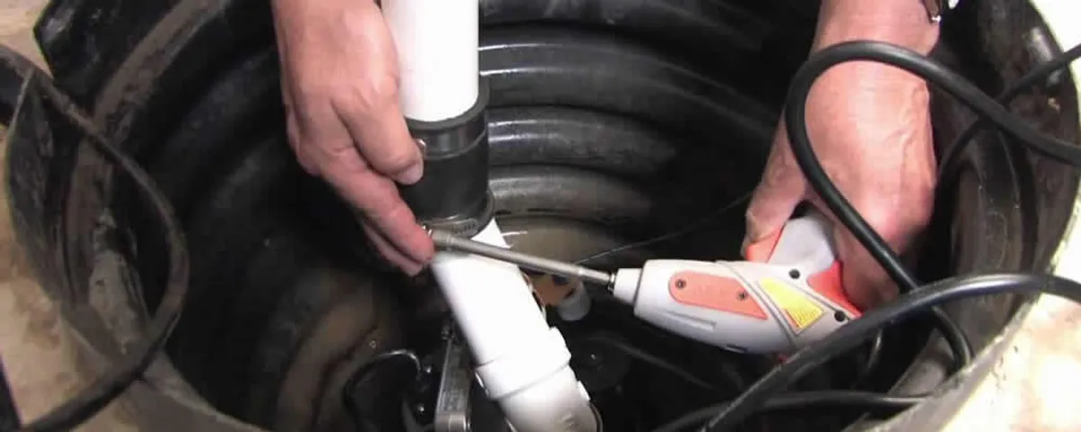 Sump pump installation technician connecting PVC discharge piping in Fort Lauderdale, FL